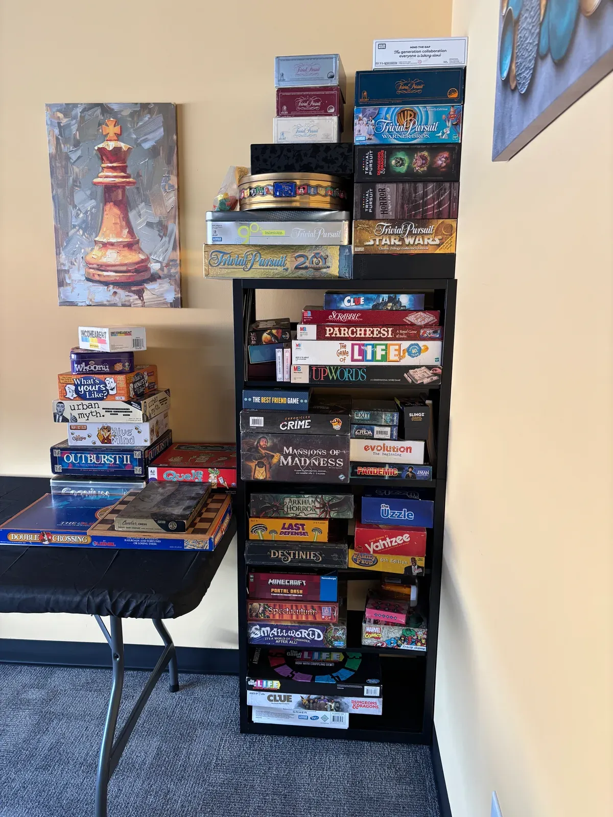 A shelf stacked with board games, including Clue, Scrabble, Trivial Pursuit and Arkham Horror